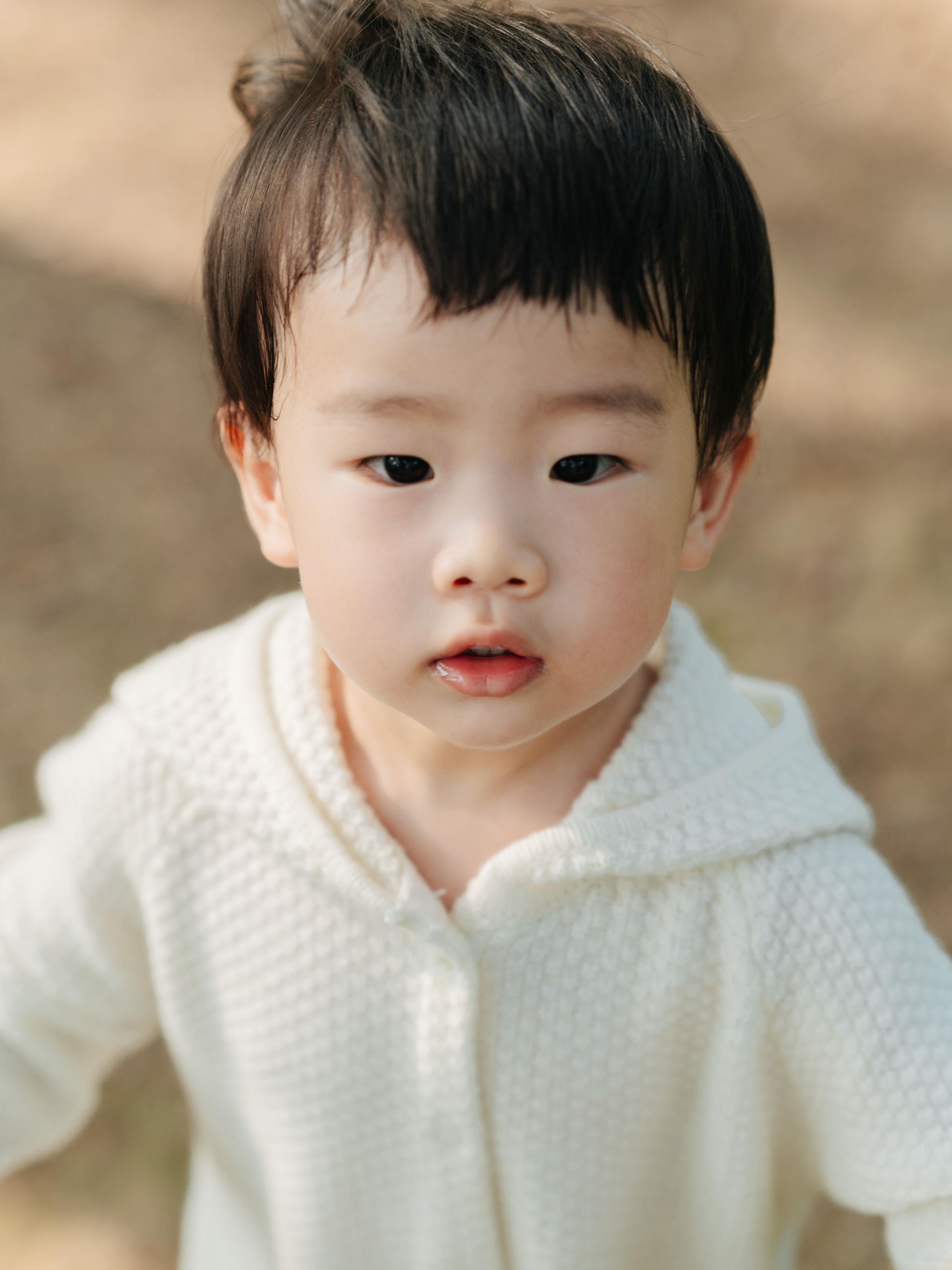 ArborTree 100% cashmere hooded onesie for kids, soft beige with front zipper and hood, cozy and luxurious children's clothing.