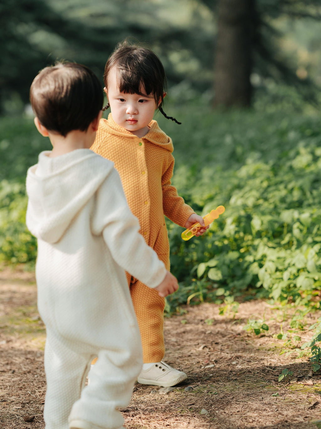 ArborTree 100% cashmere hooded onesie for kids, soft beige fabric with a hood and button closure, cozy and natural.