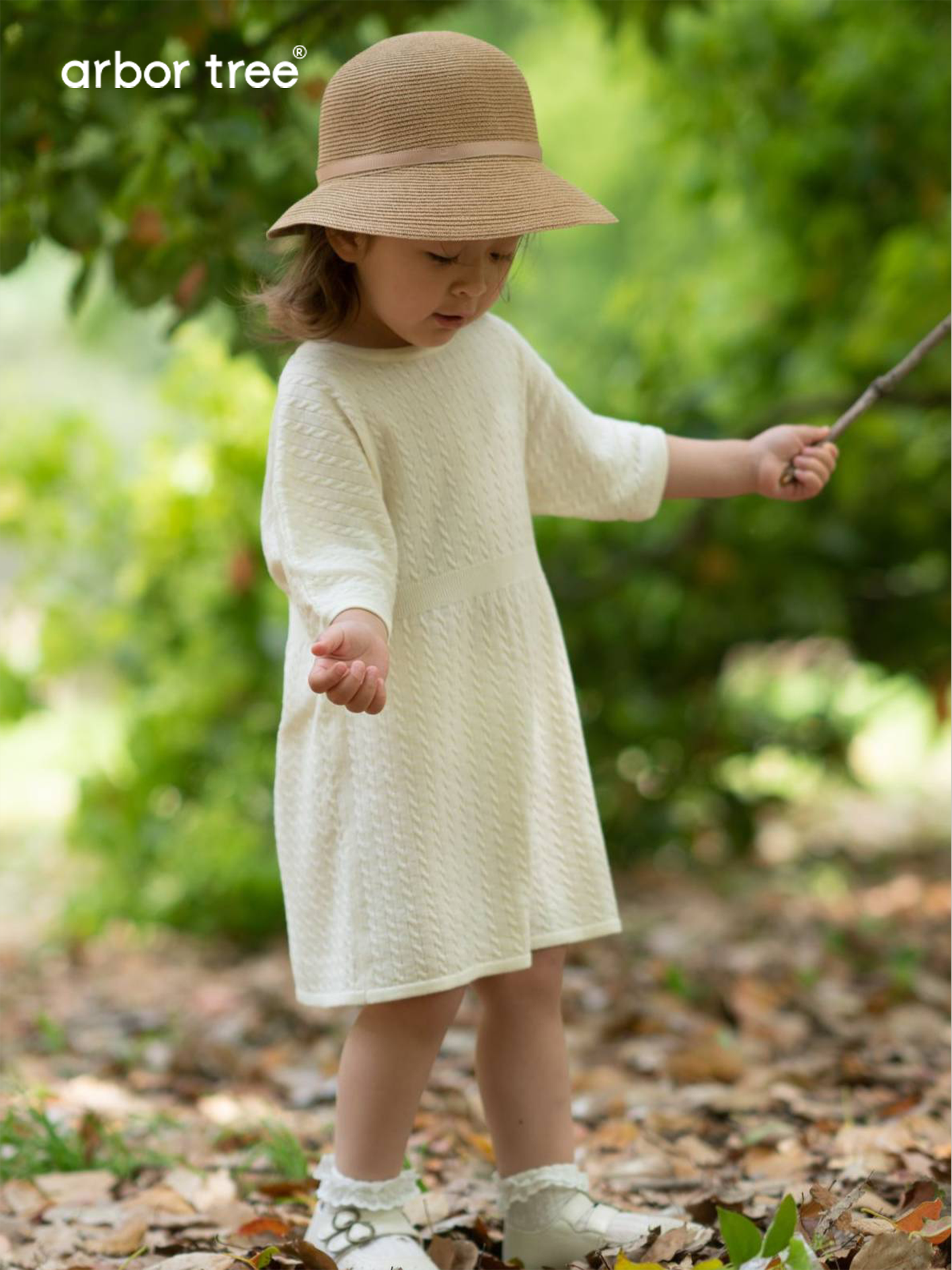 ArborTree 100% Merino superfine wool baby dress in soft pastel pink with long sleeves and delicate detailing.