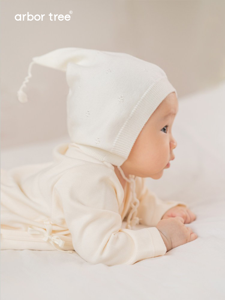 Organic cotton baby tie-up harness by ArborTree, soft natural fabric with adjustable straps for secure baby wear.