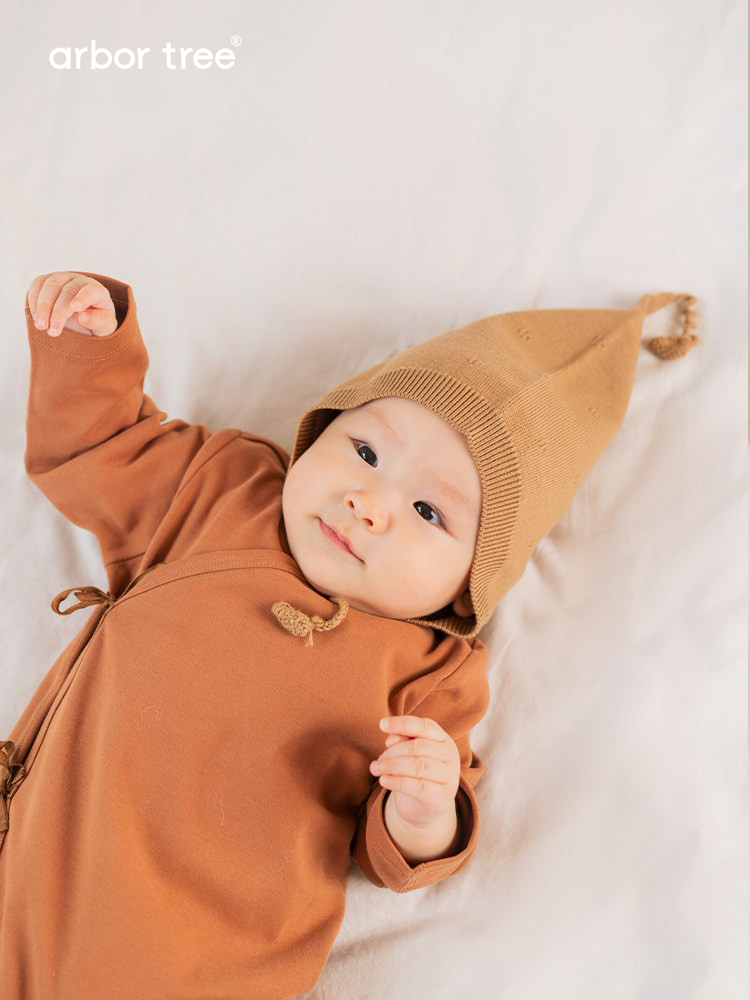 Organic cotton baby tie-up harness by ArborTree, soft natural fabric, adjustable straps, designed for gentle support and comfort.