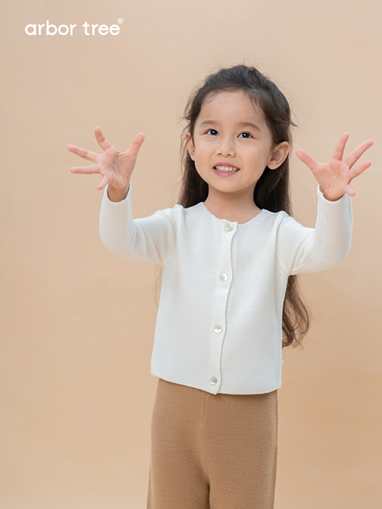Soft white Merino Wool baby cardigan coat by ArborTree, featuring a cozy knit design and button closure for infants.